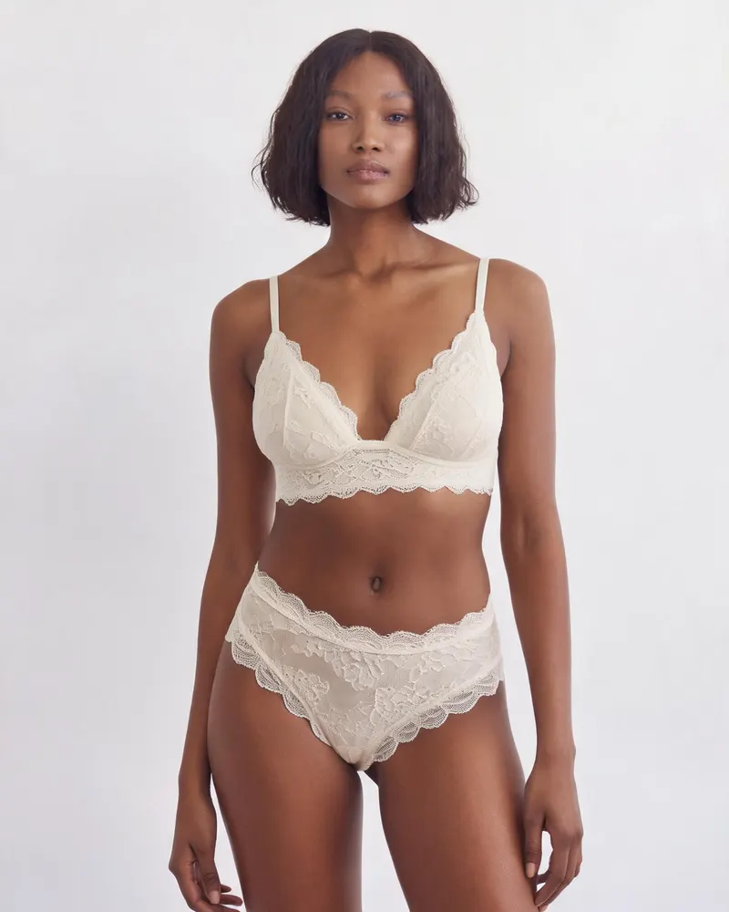 Celeste Lace Bralette in Ivory, front view on the model: a soft non-wired triangle bralette in scalloped stretch lace with lightly lined cups and adjustable straps
