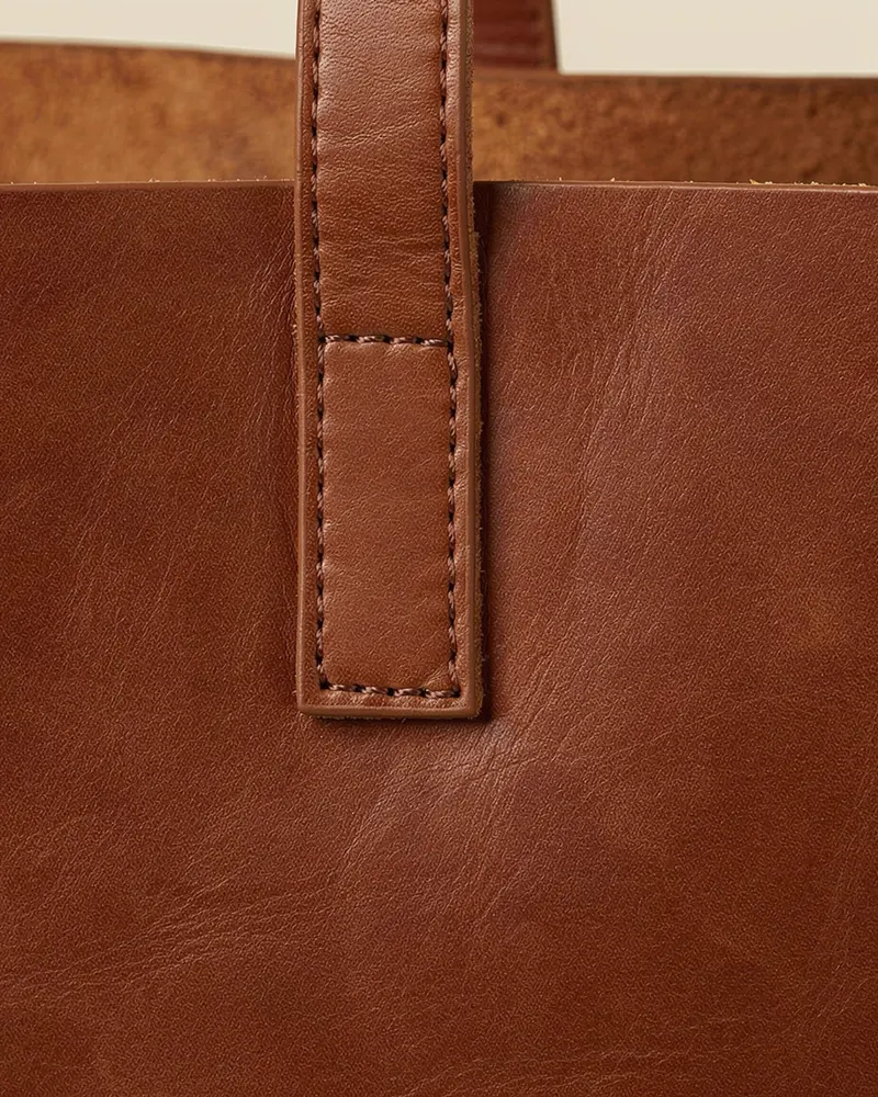 Close-up of the Craster Leather Tote Bag in Conker: fits a 14-inch laptop