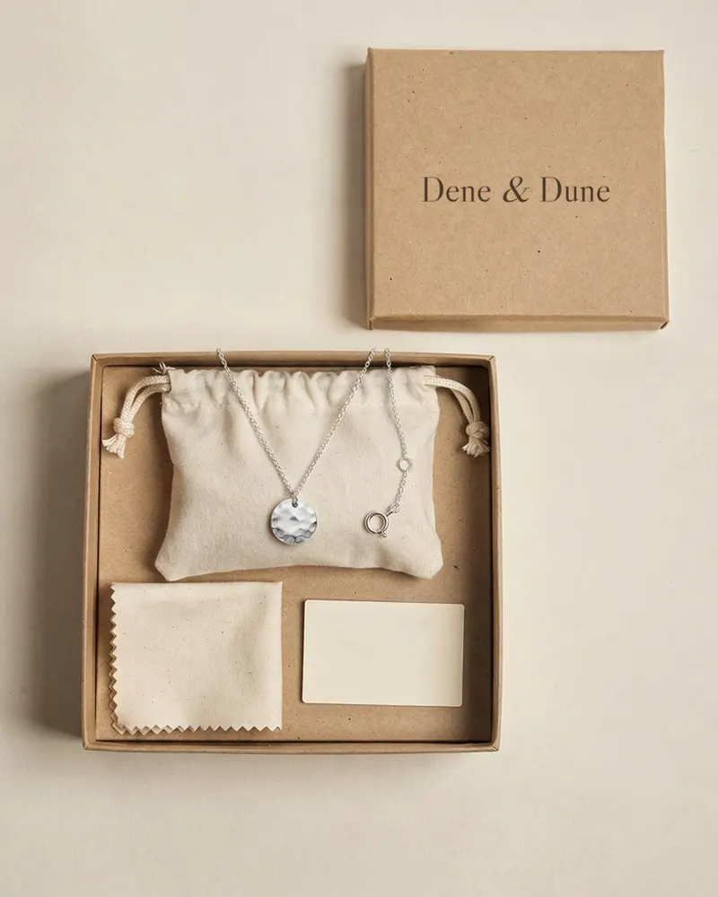 Hammered Disc Necklace in Recycled Silver in its Dene & Dune gift box with pouch and care card
