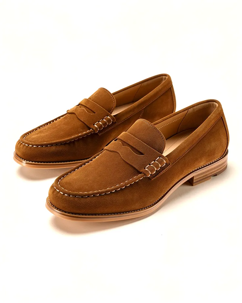 Hazel Suede Penny Loafer in Tobacco, a pair shown at three-quarters: soft suede penny loafers with a leather lining and a flexible rubber sole