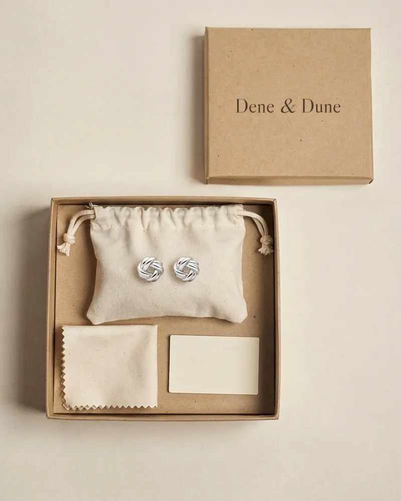 Lindisfarne Knot Stud Earrings in Recycled Silver in its Dene & Dune gift box with pouch and care card