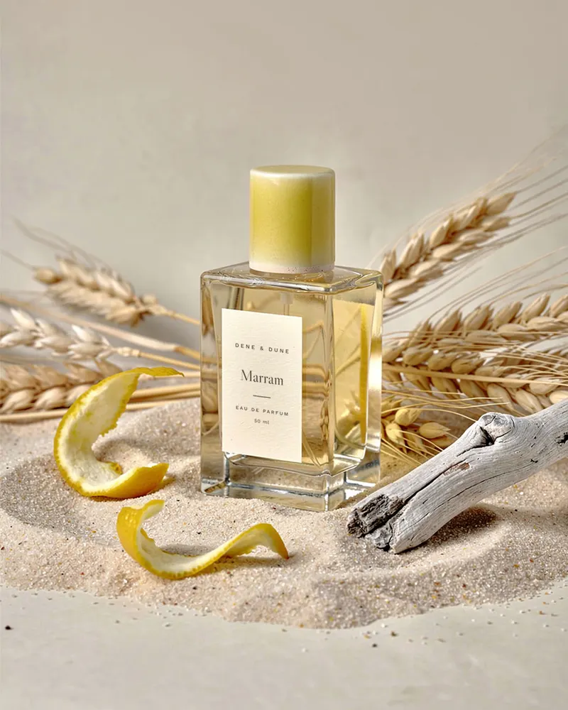 Marram Eau de Parfum with raw materials from its notes: dried marram grass, lemon peel and bleached driftwood on sand