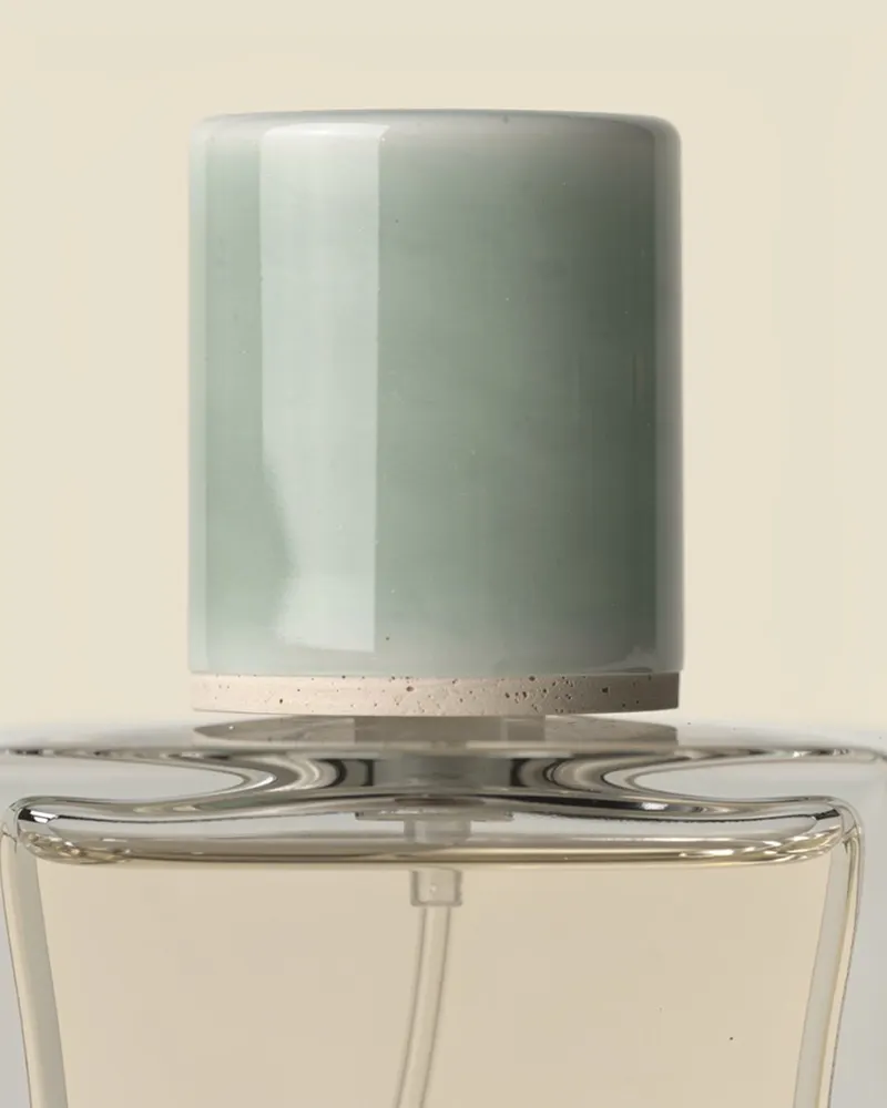 Close-up of the Northlight Eau de Parfum: hand-glazed stoneware cap in pale sea-glass green